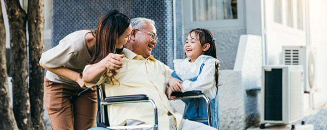 Smiling, midlife female caring for her father and young daughter.