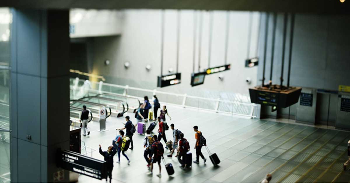 Travellers with luggage at the airport escalator